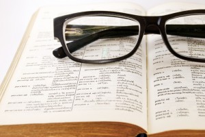 closeup of old dictionary and glasses